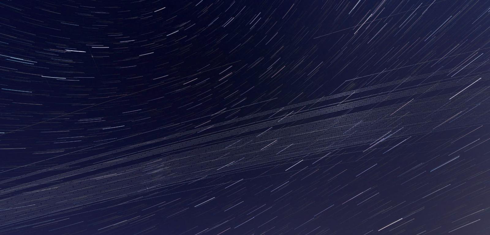 Smuga na nocnym niebie pozostawiona przez piątą serię satelitów ­tworzących konstelację Starlink.
