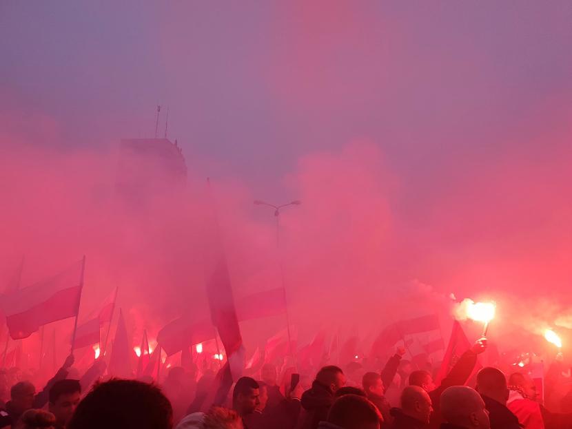 Uczestnicy marszu narodowców odpalają race.