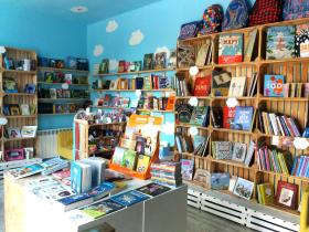 Chmurdalia, Wrocław, ul. Lakiernicza 211. Dlaczego warto prowadzić księgarnię kameralną?Moja księgarnia ma dopiero dwa miesiące, więc jeszcze nie wiem, czy uda się ją utrzymać, ale zależy na tym bardzo mnie i lokalnej społeczności. To księgarnia dla dzieci, do stworzenia jej zainspirowała mnie warszawska Księgarnia Bullerbyn. Mieścimy się na Grabiszynku, spokojnej, zielonej dzielnicy Wrocławia, naprzeciwko szkoły. Klienci często pytają z wyraźną troską: „Czy jest ruch?”. Widać, że zależy im, żeby miejsce się utrzymało. Wielu deklaruje z lokalnym patriotyzmem, że tylko tutaj będzie kupować książki i artykuły szkolne. Jedna mama wpadła na pomysł przed urodzinami dziecka, żeby dziecko zrobiło swoją listę wymarzonych prezentów u nas i wszyscy zaproszeni goście i rodzina zrobili urodzinowe zakupy właśnie tu. Teraz jestem proszona o przygotowanie bonów prezentowych dla kolejnych małych jubilatek.Za co nas lubią? Przede wszystkim za dobór książek. Często słyszę: „Jakie Pani ma piękne książki”. Ludzie są zmęczeni zakupami w dużych sieciowych księgarniach, bo trzeba zmarnować sporo czasu, żeby wyłowić książki piękne i wartościowe spośród ogromnej ilości kiczu.Tak jak pisze Grzegorz Leszczyński w „Wielkie małe książki”: „Złych książek ukazuje się nieporównanie więcej niż dobrych. Wizyta w księgarni bywa przeżyciem stresującym – doprawdy nie wiadomo, co dziecku czy nastolatkowi kupować, czym kierować się w decyzjach, jak w tsunami kiczu i miernoty, które zalewa półki z książkami, znaleźć rzeczy wartościowe”.Poza tym moja księgarnia dzięki swojemu umiejscowieniu naprzeciwko szkoły pełni też w pewnym stopniu rolę „ośrodka kultury”. Dzieci wstępują tu po szkole, buszują po półkach i po chwili znikają porozsiadane na kanapach, pufach i pochłonięte lekturą. I to właściwie jest najpiękniejsze, choć z punktu widzenia biznesowego dochodu materialnego księgarni nie przynosi. Ja wiem, że te dzieci, które pokochały to miejsce, wrócą tu w swoje urodziny i wydadzą wszystkie pieniądze na wymarzoną książkę. A ich rodzice też się cieszą, że dzieci tak spędzają czas po szkole. Poza tym, przynajmniej raz w tygodniu prowadzimy tanie warsztaty z rękodzieła – malowanie ceramiki, decoupage, szycie – i to też daje wielką satysfakcję. Patrzenie, jak dzieci są kreatywne, ile radości daje im twórcze działanie i jak są dumne z tego, że stworzyły coś użytecznego i pięknego.2. Skąd pomysł na taką, a nie inną nazwę księgarni?Nazwa księgarni jest zaczerpnięta oczywiście z książki. W „Piaskowej Górze” Joanny Bator bohaterka Dominika Chmura słysząc cytat z Leśmiana: „coś srebrnego dzieje się w chmur dali”, wyobraża sobie „Chmurdalię” – szczęśliwą, rajską krainę w chmurach… — Paulina Koksa.