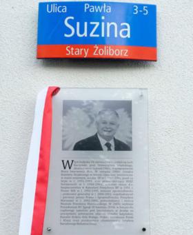 Tablica upamiętniająca Lecha Kaczyńskiego ustanowiona na budynku przy ulicy Pawła Suzina 3 w Warszawie, miejscu jego urodzenia. Odsłonięta w maju 2015 roku.