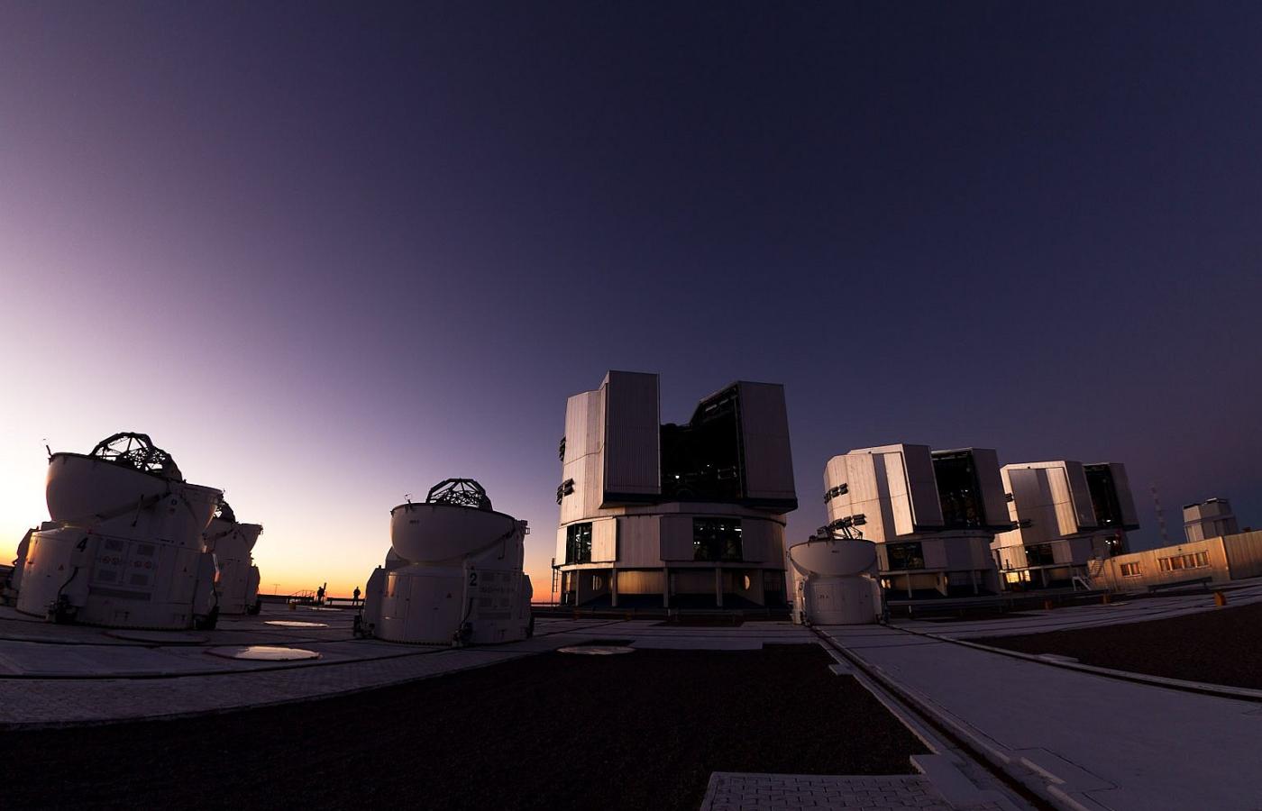 Zmierzch. Teleskopy VLT już otwarte. Światła widoczne wewnątrz to znak, że trwa przegląd techniczny. Przed chwilą ziemia na Atacamie zadrżała - trzeba sprawdzić urządzenie.