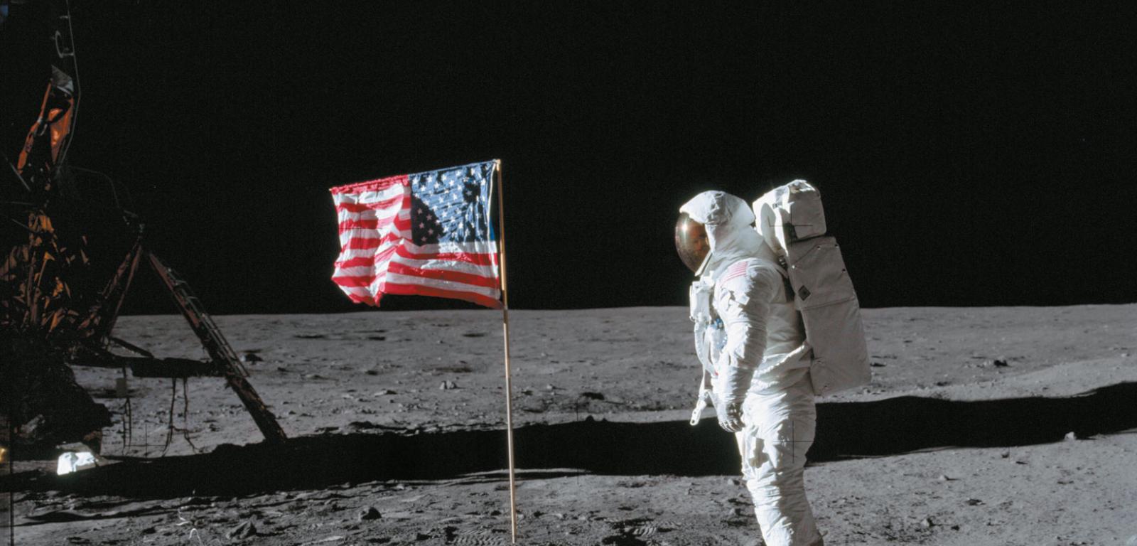 Astronauta Buzz Aldrin stoi przy fladze USA zatkniętej na Księżycu w lipcu 1969 roku.