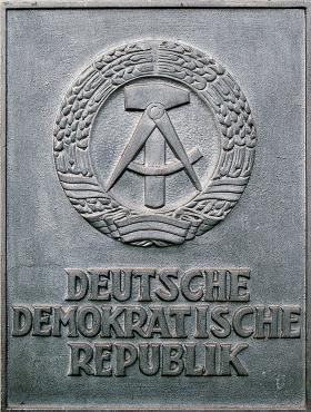 Godło Niemieckiej Republiki Demokratycznej, przyjęte w 1955 r.: młot (robotnicy), cyrkiel (inteligencja pracująca) i kłosy zboża (chłopi)