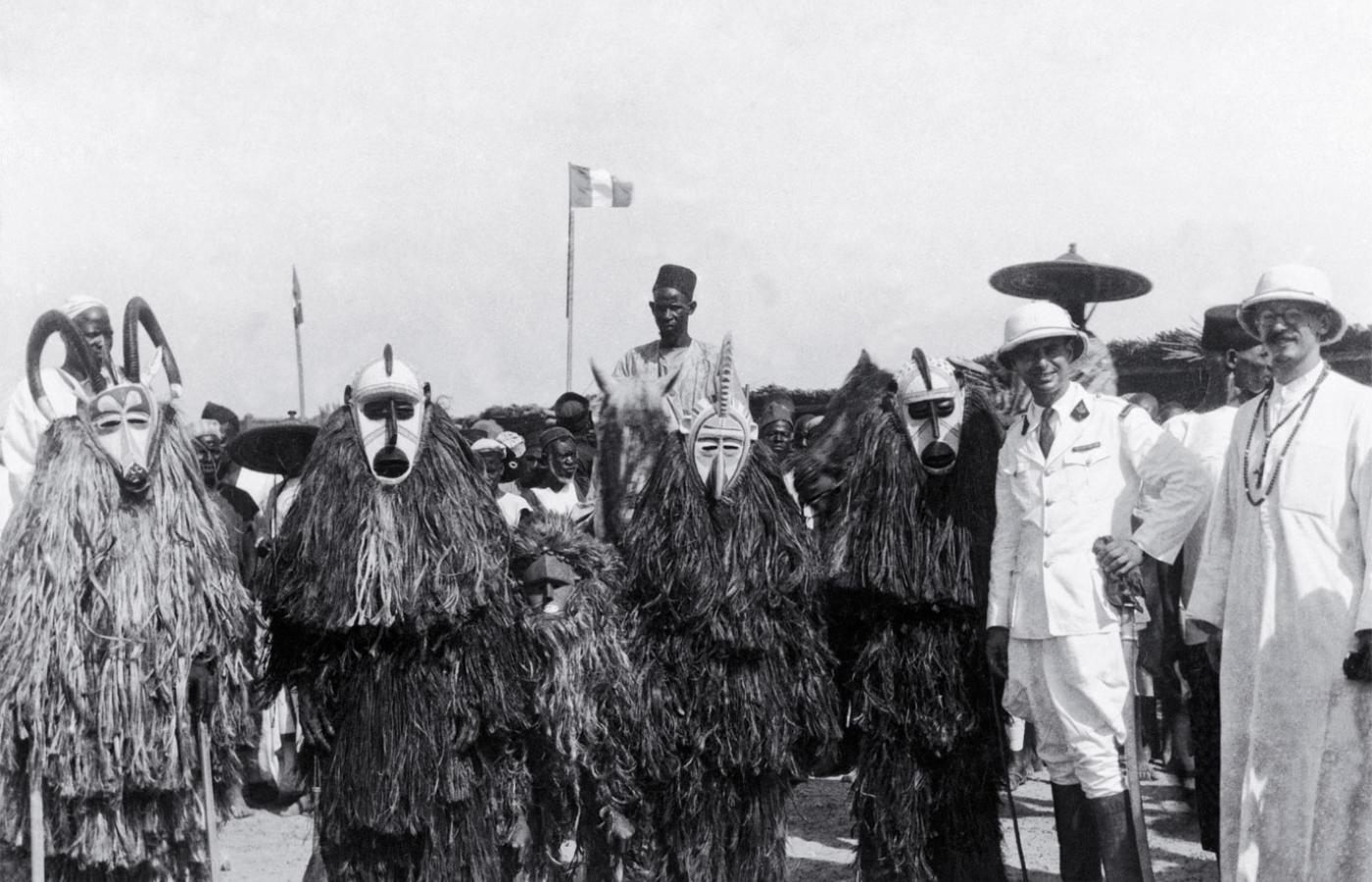 Malijczycy w maskach i europejscy misjonarze, ok. 1930 r.
