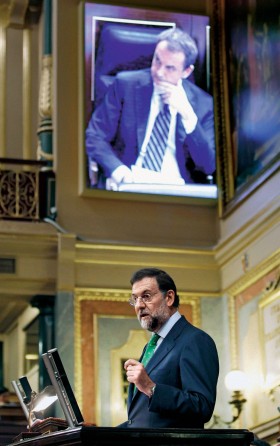 Przemawia Mariano Rajoy, ale to wcale nie znaczy, że mówi coś więcej niż słuchający go José Zapatero.