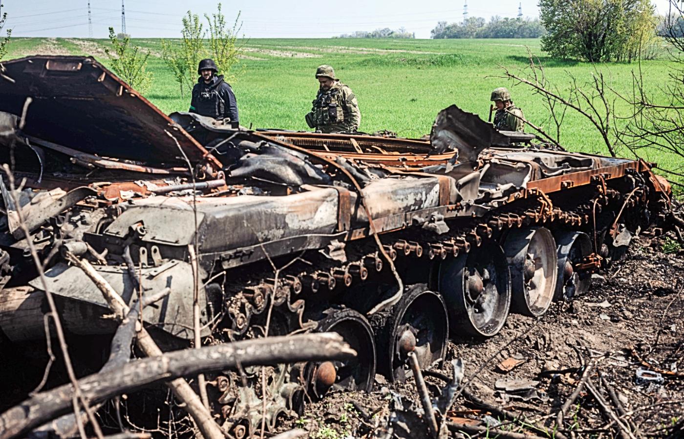 Ukraińscy żołnierze obok zniszczonego rosyjskiego czołgu. Okolice Charkowa, maj 2022 r.