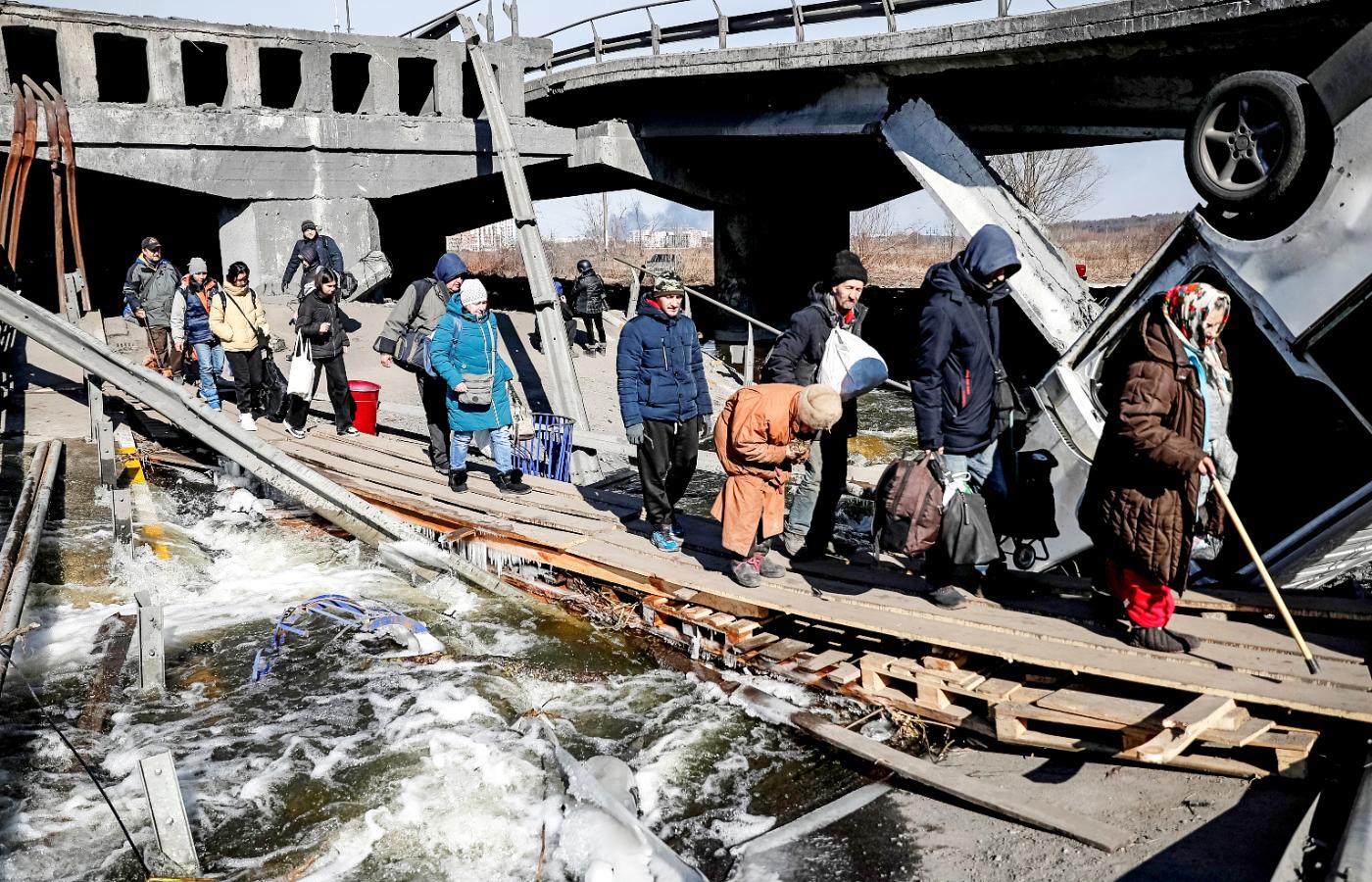 Mieszkańcy Irpienia ewakuują się z miasta przez kładkę obok zniszczonego mostu na rzece Irpień. Marzec 2022 r.