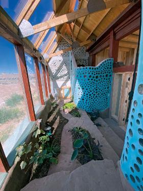 Łazienka w jednym z samowystarczalnych domów w Taos w Nowym Meksyku, ze ścianami działowymi z butelek obłożonych gliną.