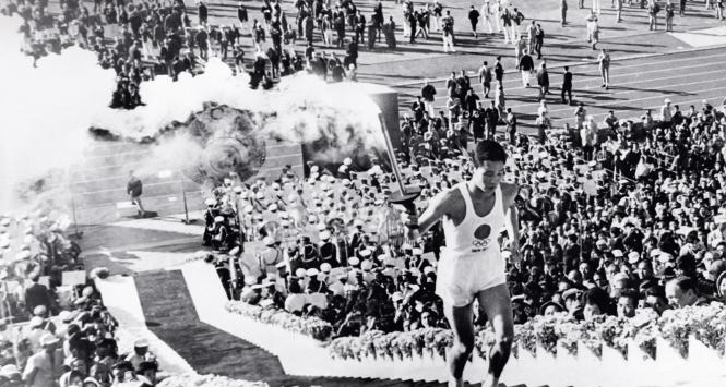 Yoshinari Sakai, japoński symbol narodowy ze zniczem olimpijskim.