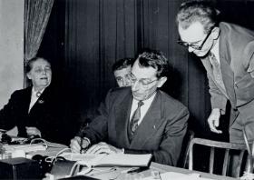 Fryderyk Joliot-Curie podpisuje petycję przeciwko wojnie nuklearnej, spotkanie Światowej Rady Pokoju, Wiedeń 1955 r.