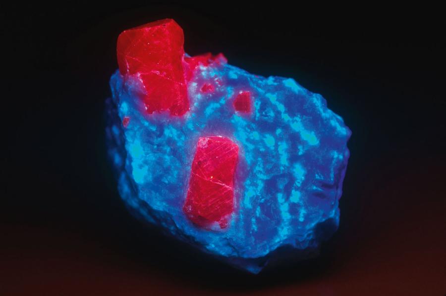 Kryształy rubinu (czerwony) na dolomicie (niebieski). Fotografia wykonana w świetle ultrafioletowym.