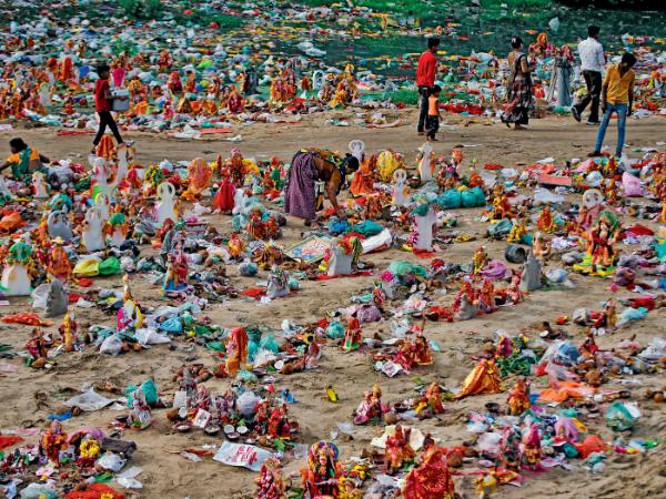 Mieszkańcy Ahmadabadu sprzątają po uroczystościach, wyławiają i zbierają z brzegów rzeki dary, które mogą się przydać.