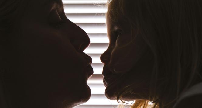 Kristina Leos (po lewej), która po narodzinach córki Victorii przeszła ciężką depresję, pochyla się, by pocałować swoje dziecko.