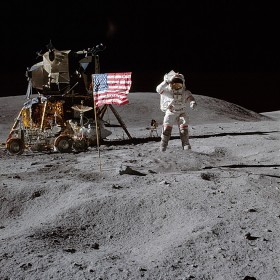 Dowódca lądującej na Księżycu misji Apollo 16, John W. Young, zdaje się salutować amerykańskiej fladze. Za nim widoczny moduł księżycowy „Orion” i pojazd Lunar Raving Vehicle.