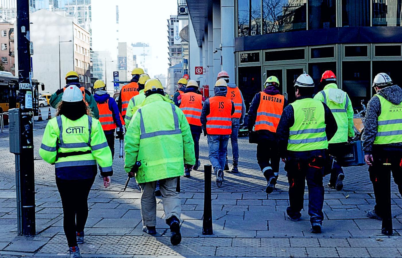 Robotnicy budowlani w Warszawie w drodze do pracy