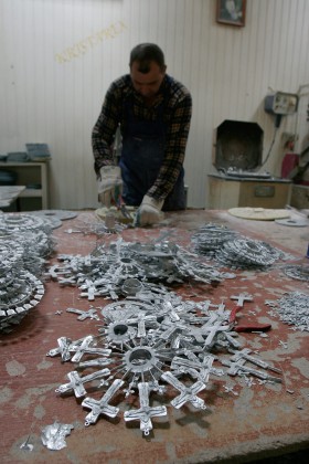 Ręce pana Bogusia precyzyjnie dłubią w matrycy krzyż.