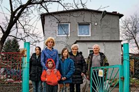 Karina Ławniczak z dziećmi, siostrą i rodzicami przed ich domem na działce, gdzie mieszkają.