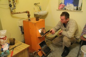 Wnuk Stefanii Wojtalik przy piecu w przybudowówce.