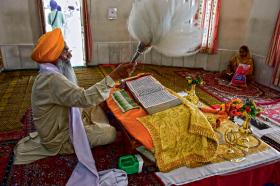 Sikh recytujący wersety świętej księgi „Guru Granth Sahib”