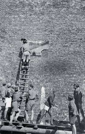 Harcerze jadący na obóz koło Jeleniej Góry usuwają niemieckie napisy i tablice na stacjach kolejowych, na których zatrzymywał się ich pociąg, sierpień 1945 r.