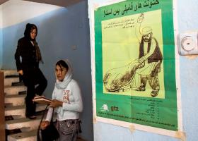 Na kabulskim uniwersytecie. Na ścianie plakat edukacyjny przeciw przemocy domowej.