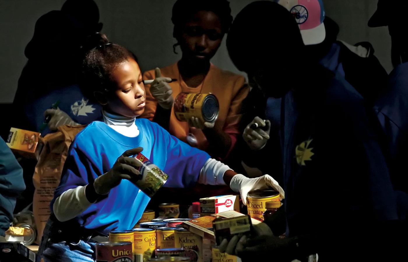 Młoda wolontariuszka bierze udział w przygotowywaniu paczek w ramach akcji jednego z banków żywności w Toronto.