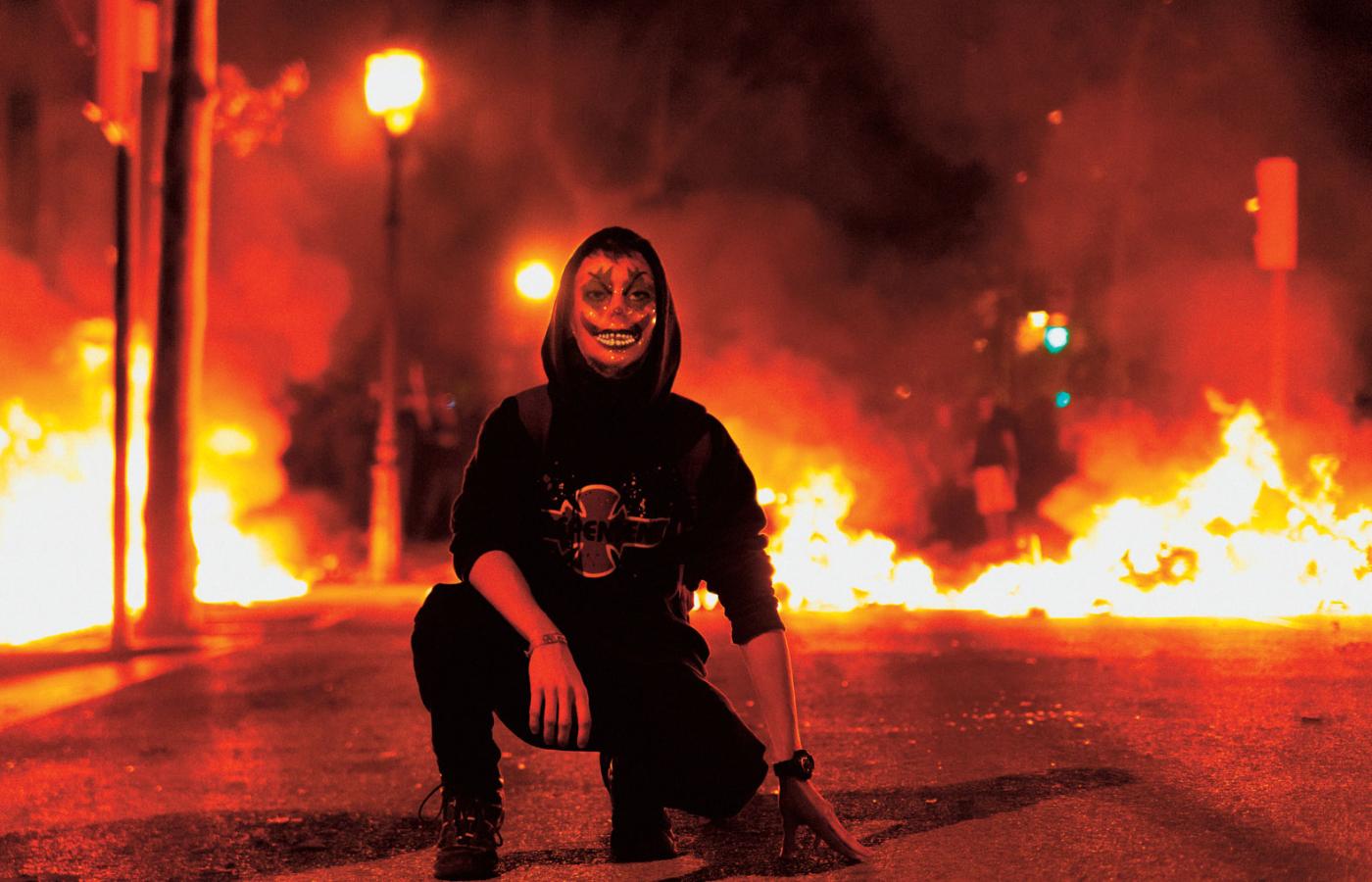 Wielu manifestantów zakrywa dziś twarze maskami Jokera. Na fot. zamieszki w Barcelonie.