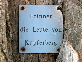 Na jednym z drzew ktoś przykręcił tabliczkę „Pamięci ludzi z Kupferbergu” – to jeden z nielicznych śladów Niemców w miasteczku.