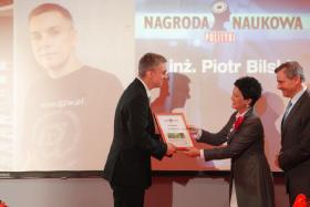 dr Piotr Bilski odbiera portfel z czekiem oraz dyplom