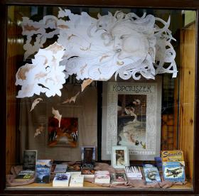 Makama, Krapkowice, ul. Opolska 11. Dlaczego warto prowadzić księgarnię kameralną?Księgarnie niezależne powinny istnieć dlatego, że do zwykłego handlu książką wnoszą indywidualny charakter, odrębne style, różne profile działalności. To, jak wygląda taka księgarnia, co sprzedaje, czym przyciąga klientów, zależy przede wszystkim od właściciela i jego pasji. Sądzę, że naszą księgarnię Makama wyróżniają dwie cechy: wystawy (tworzone z dużym udziałem własnych pomysłów, projektów, ręcznie wykonanych dekoracji) oraz okazjonalne zabawy, konkursy, skierowane zwłaszcza do dzieci, których przebieg jest przeważnie wymyślany przeze mnie, za każdym razem odmiennie. Do wielu takich spotkań przygotowuję również niepowtarzalne rekwizyty. To jest moja pasja.Jestem przekonana, że większość księgarń niezależnych powstaje, lub istnieje, dzięki determinacji konkretnych osób i ich potrzebie przekazania innym własnej fascynacji książkami. Skoro potrzeba nam jak najwięcej sposobów do zachęcenia społeczeństwa do czytania, to jednym z nich są właśnie księgarnie, takie, które przyciągają do książek swoją niepowtarzalnością. Argumentacja, że dostępność książek w internecie lub sieciach handlowych wystarczy, by zaspokoić popyt na nie, nie uwzględnia faktu, że najpierw trzeba ten popyt wytworzyć (co oznacza rozmiłować Polaków w czytaniu od najmłodszych lat). Dziecko, które nie ma okazji dostatecznie często pobuszować między półkami z książkami, wybrać lektury dla siebie, czuć się w księgarni jak w miejscu dobrze sobie znanym i atrakcyjnym, nie wyrośnie na miłośnika, który będzie odczuwał potrzebę przeczytania, posiadania, poszukania książki.2. Skąd pomysł na taką, a nie inną nazwę księgarni?Historia naszej nazwy jest dość banalna. Kiedy na początku lat 90. XX wieku zapadła decyzja o prywatyzacji księgarni „Domu Książki”, w której kierowniczką przez 30 lat była moja mama, podjęliśmy ważną decyzję o utworzeniu spółki rodzinnej. Pełni entuzjazmu i wizji nowoczesnej księgarni, potrzebowaliśmy dla niej nazwy. Ustaliliśmy, że powinna być krótka, łatwa do zapamiętania i związana z literaturą. Ponieważ jednak nie mogliśmy dojść do konsensu, jak powinna brzmieć, otworzyłam słownik pojęć literackich na przypadkowej stronie i odczytałam pierwsze krótkie hasło: „Makama, gatunek prozy narracyjnej…”. I tak zostało. — Iwona Witkiewicz-Geisler.