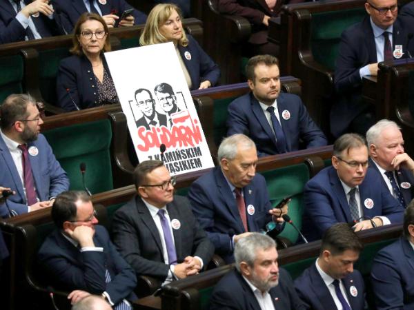 Posłowie PiS z wizerunkami Mariusza Kamińskiego i Macieja Wąsika na sali posiedzeń w Sejmie