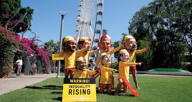 Happening aktywistów podczas szczytu państw G20 w australijskim Brisbane. Napis na tablicy: Uwaga! Rosnące nierówności.