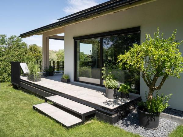 Przesuwne okno tarasowe INNOVIEW otwiera dom na ogród, tworząc eleganckie połączenie nowoczesnej architektury z naturą