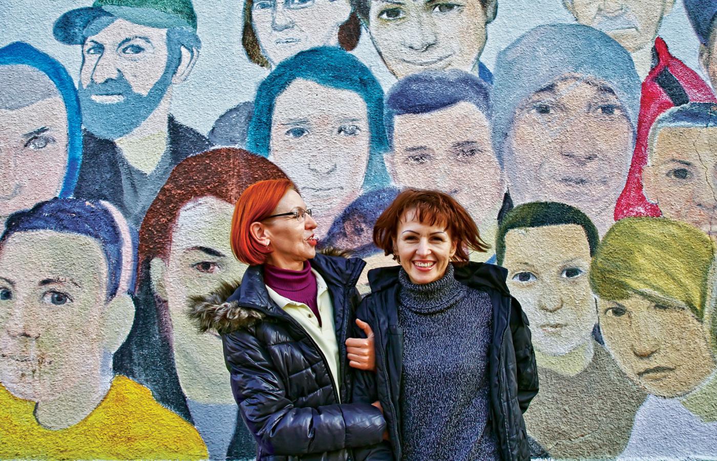 Anna, prowadząca sklep spożywczy, z córką Moniką na tle muralu z portretami mieszkańców Starych Bronowic