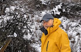 Zbigniew Achramowicz przed karczowiskiem na miejscu protestanckiego cmentarza