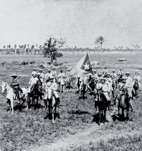 Kawalerzyści kubańscy w pobliżu Remedios, prowincja Santa Clara, jeden z nich trzyma kubańską flagę, 1898 r.