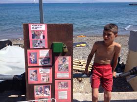 Ogłoszenie lokalnego towarzystwa przyjaciół zwierząt, obok koczowiska imigrantów przy miejskiej plaży: „Nie dokarmiaj i nie kupuj [zwierząt], gdy bezdomne psy i koty umierają – adoptuj je”.