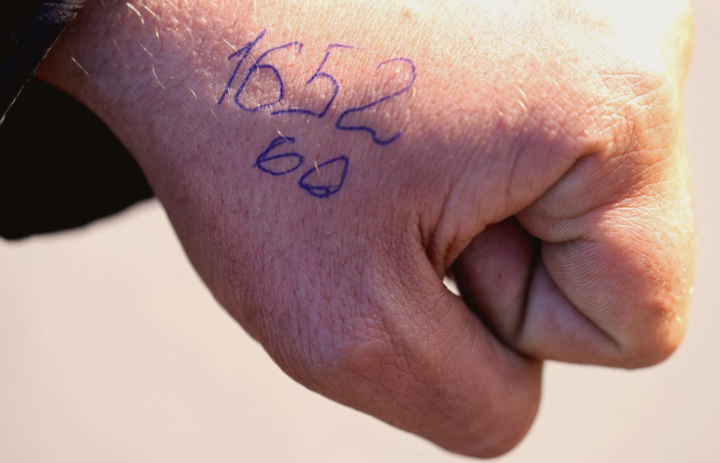 Kolejkowy numer na ręce jednego z przywiezionych do obozu w Bezimienne, 7 maja 2022 r.