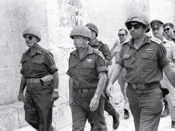 Szef Sztabu Generalnego Sił Zbrojnych Izraela Icchak Rabin (w środku) z ministrem obrony gen. Mosze Dajanem (z lewej) i lokalnym dowódcą idą do Ściany Płaczu w Jerozolimie podczas wojny sześciodniowej, czerwiec 1967 r.