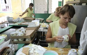 Monika Pietruszka, nakłada kalkę na ceramikę.