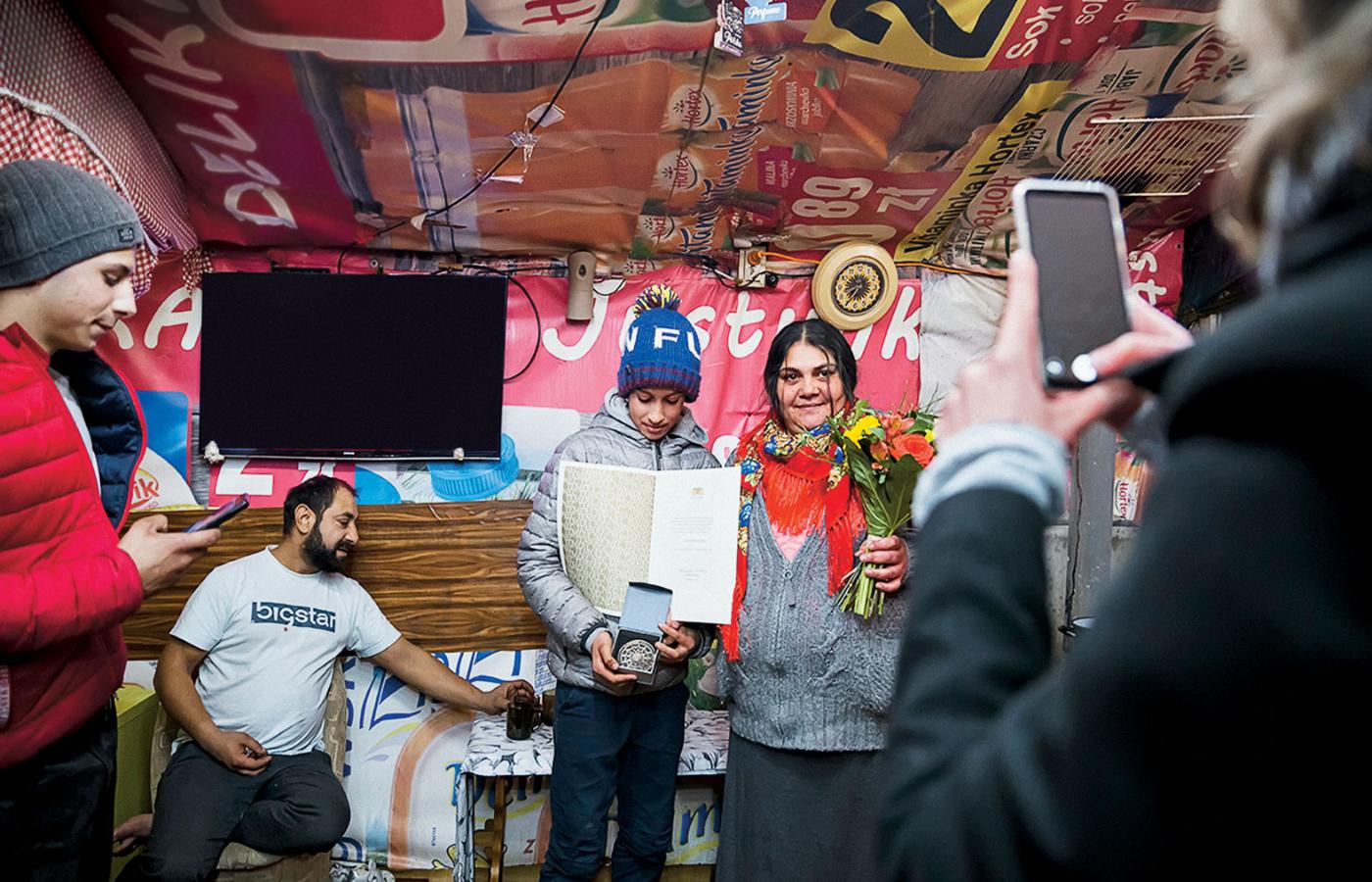 Mindra Caldarar z rodziną pokazuje w osadzie Nagrodę Równości, którą właśnie uhonorowało ją miasto Gdańsk.