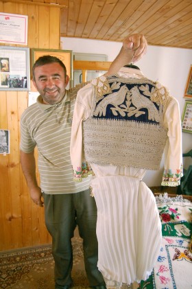 Yahiya Maznikar, autor czterech książek o historii Gory z dumą prezentuje tradycyjną suknię przygotowaną przez jego żonę