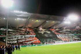 Baner kibiców Legii z głową Chrystusa i hasłem napisanym szwabachą „Boże, chroń fanatyków”