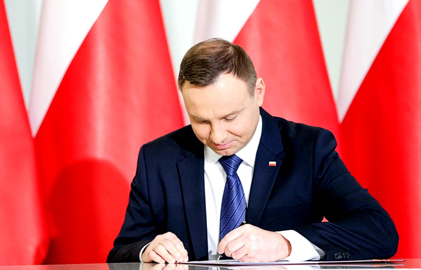 Andrzej Duda podpisuje ustawę.