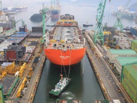 „Skarv”  - pływająca platforma do wydobycia ropy i gazu. Jest tak wielka, że nie mogła się zmieścić w Kanale Sueskim. Tu w stoczni w Korei przed wypłynięciem do Europy. Pomagający mu pchacz został specjalnie przeniesiony suwnicą i spuszony do doku.