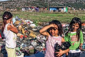 Dzieci z obozu położonego obok miejskiego wysypiska przegrzebują śmieci.