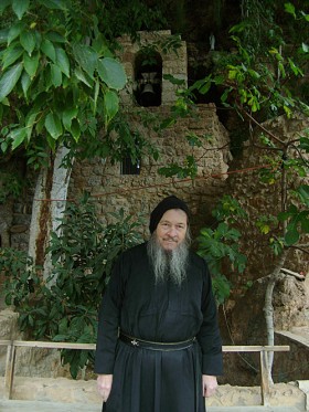 O. Dario na tle kościoła Najświętszej Marii Panny i jej dzwonnicy. Z tylu schody prowadza do pomieszczenia przeznaczonego do spania oraz do wyjścia. W środku rośnie rozłożysty orzechowiec, obok znajduje sie mały ogródek.