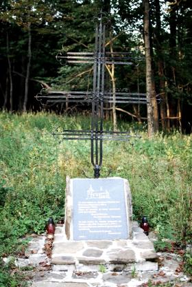 Krzyż z wieży cerkwi, fragment podmurówki i pamiątkowa tablica po cerkwi św. Michała Archanioła