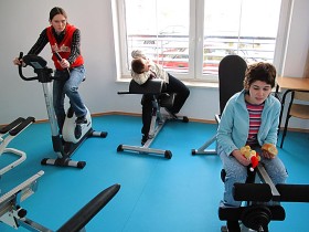 Dzieci z klasy terapeutycznej podczas ćwiczeń w siłowni w kompleksie hali sportowej z zapleczem rehabilitacyjnym