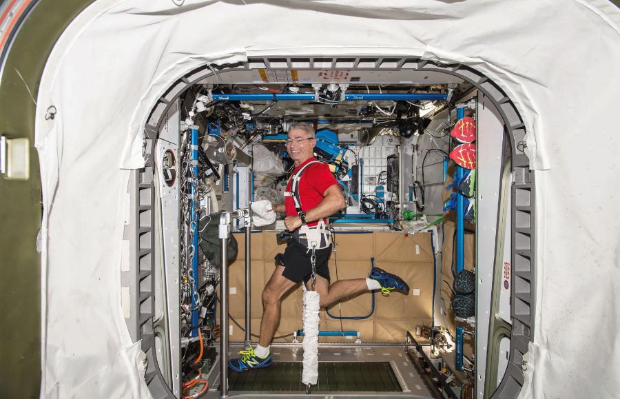 Astronauta Mark Vande Hei podczas ćwiczeń na bieżni z uprzężą.